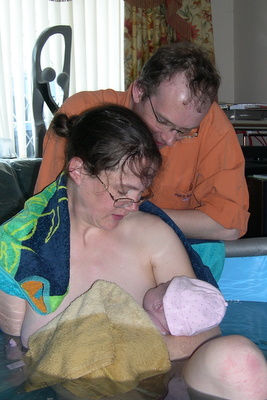 mother and father gazing at baby after birth 